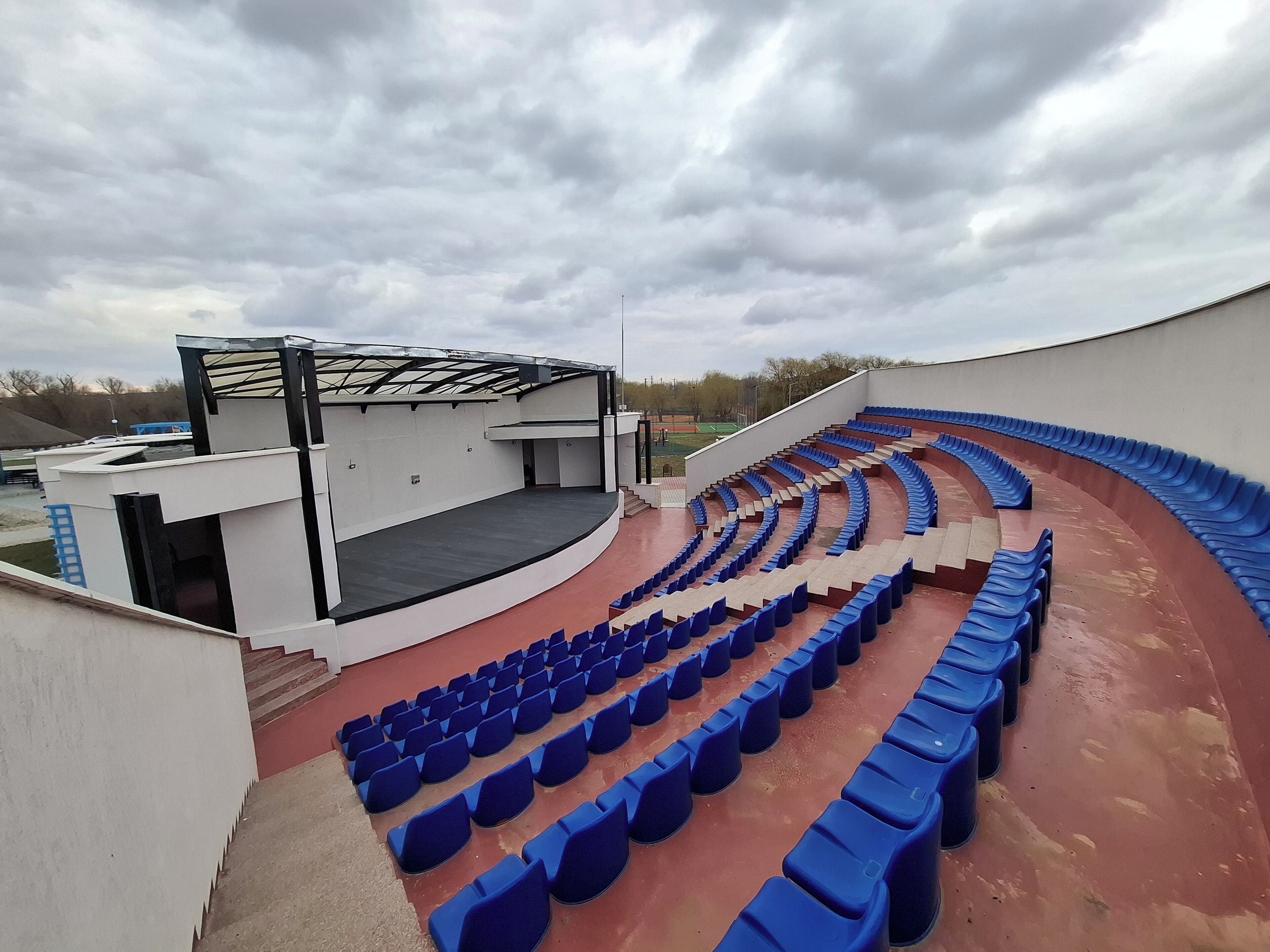 Un anfiteatro al aire libre con asientos escalonados y un escenario.