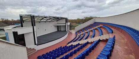 Un anfiteatro al aire libre con asientos escalonados y un escenario.
