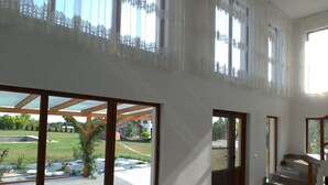A spacious interior with large sliding glass doors leading to an outdoor patio area. - Paradiso Resort (Murighiol)