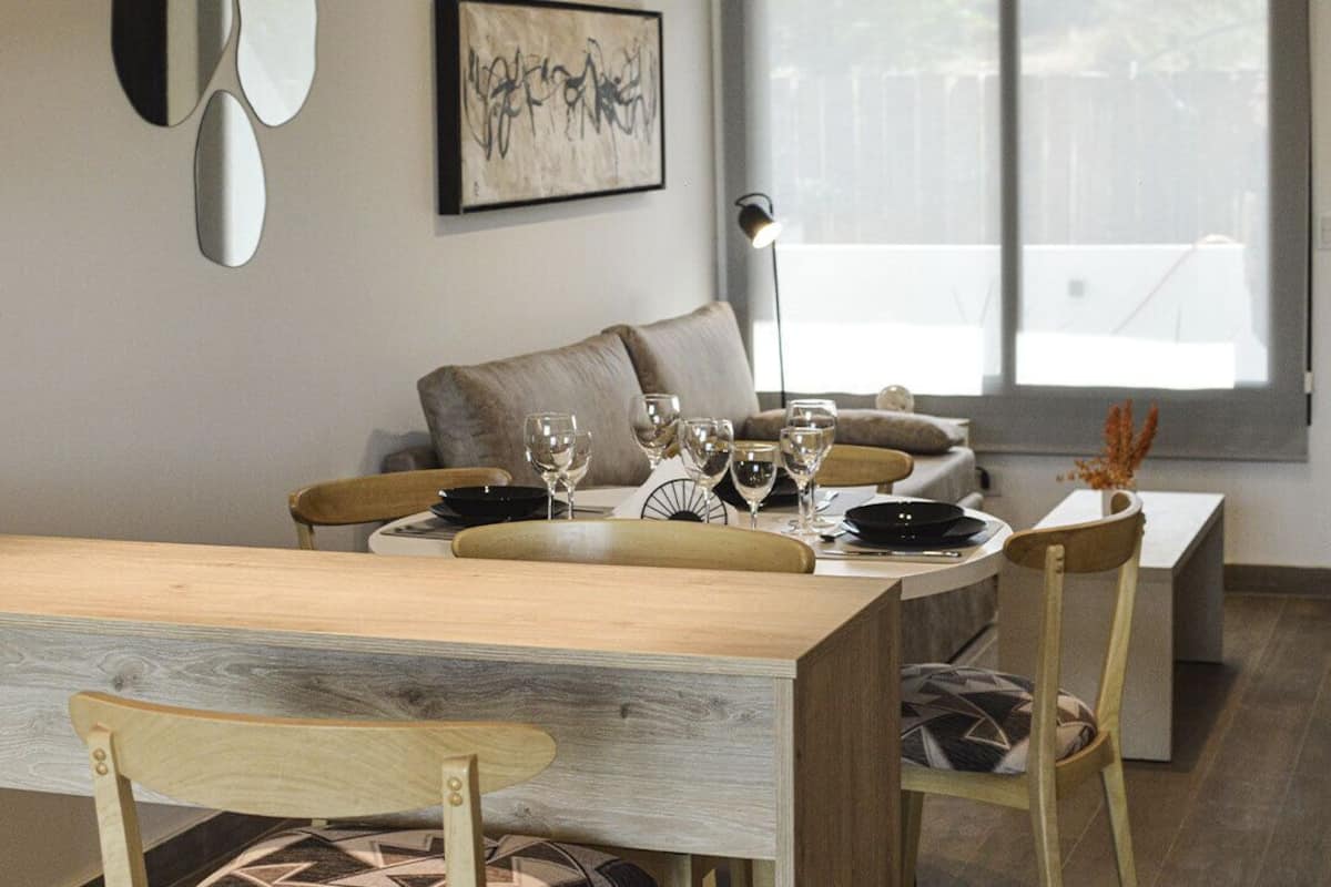 En matplats med ett träbord, stolar och en soffa i bakgrunden.