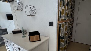 Eine Küche mit Arbeitsplatte, Schränken, einem Spülbecken und einem Vorhang mit Muster.