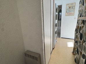 A narrow hallway with a white wall, a patterned curtain, and a poster. - Studio 4 pers, equipped kitchen, private parking, non-smoking (Arâches-la-Frasse)