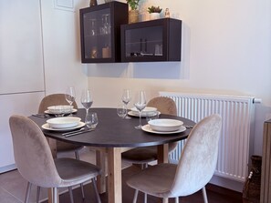 A dining area with a round table, four chairs, and a cabinet above. - New 3-bedroom apartment with garden and parking in Arâches-la-Frasse (Arâches-la-Frasse)