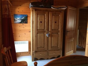 A wooden room with a large wardrobe, a bed, and a window with a picture of a mountain. - 5-bedroom chalet for 10 with private parking (Arâches-la-Frasse)