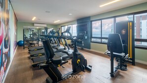 A gym with treadmills, elliptical machines, and a rowing machine. - Apts 120 m From Barra Beach With Pool and gym in the Building - Esbs (Salvador)