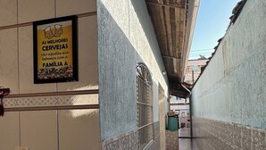 Un pasillo con paredes y piso de baldosas, que conduce a la entrada de un edificio.