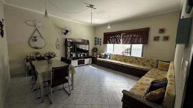 Un salón amplio con mesa de comedor, sillas, sofá y televisor.