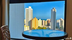 Vista urbana de uma varanda, com uma mesa redonda em primeiro plano.
