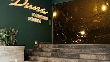 A staircase leading to a reception area with a sign reading "Duna Downtown Studios".