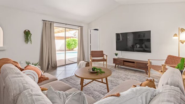 En moderne stue med sofa, sofabord og fjernsyn.