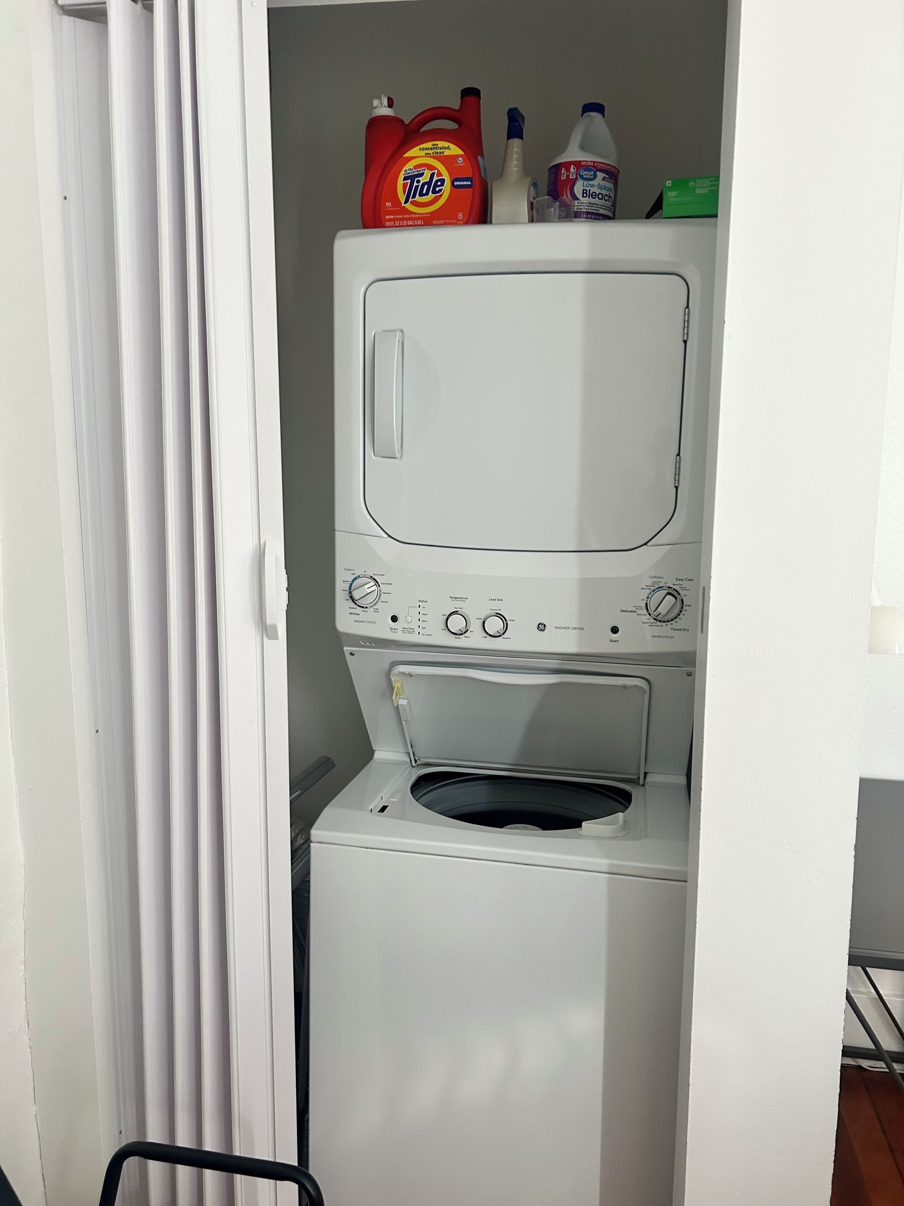 Eine kompakte, weiße Waschmaschine mit Frontlader, einer Bedienblende mit verschiedenen Programmen und einem kleinen Ablagefach darüber für Reinigungsmittel.