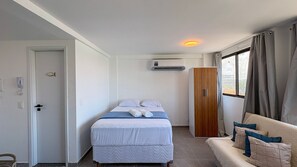 A compact bedroom with a bed, a wardrobe, and a window with curtains. - Portal dos Mares - Beira-Mar Tamandaré (Tamandaré)