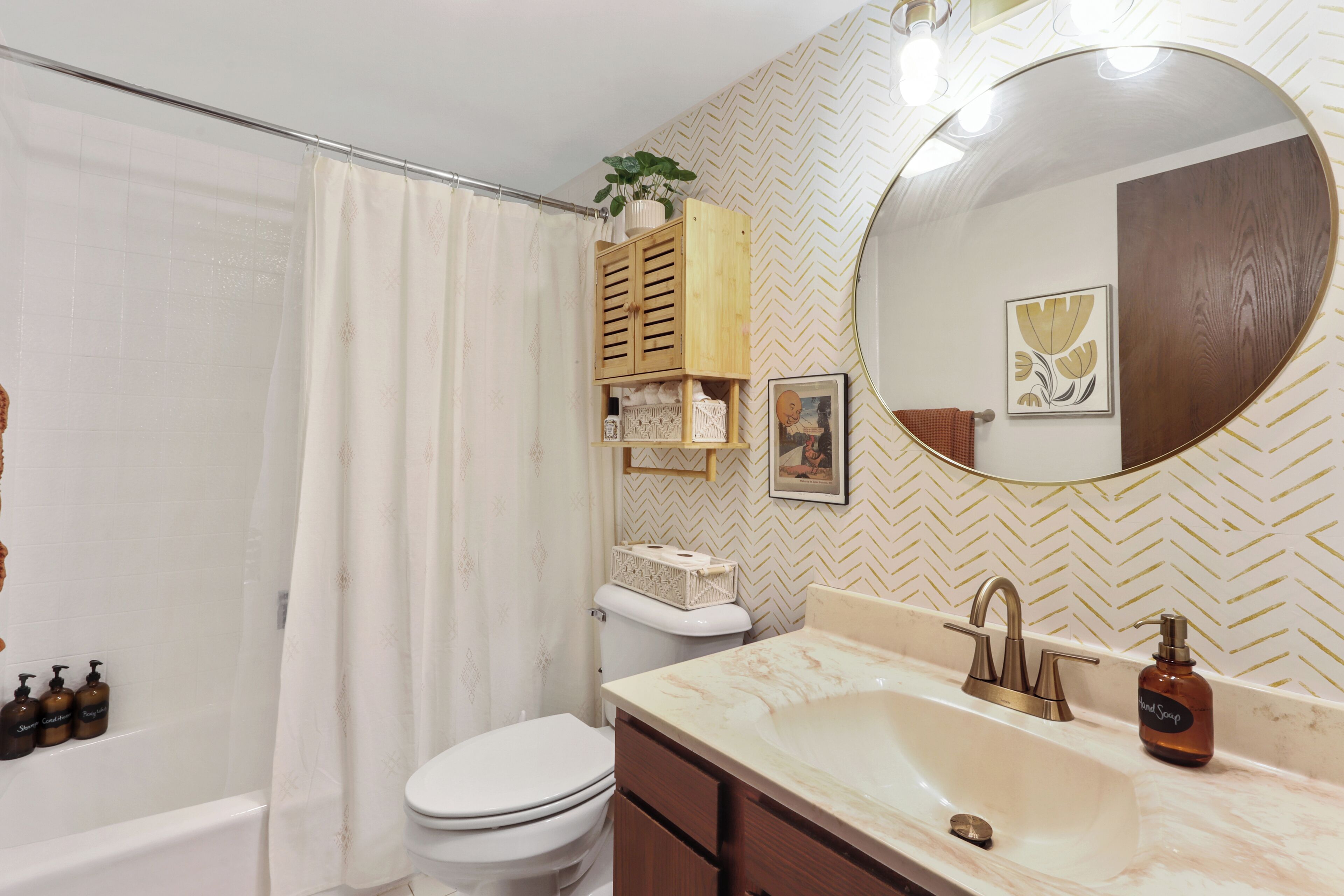 A bathroom with a white toilet, a bathtub, a sink with a mirror, and a shower curtain.