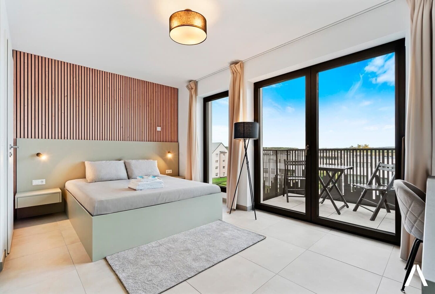 Cozy Living and Sleeping Area – Relax in a comfortable space with a plush queen-sized bed and elegant wooden accent wall.