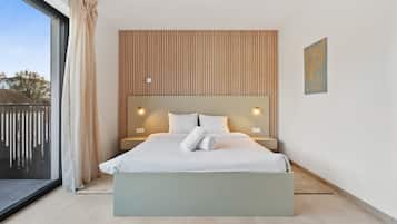 A modern bedroom with a large bed, a view through a sliding glass door, and a wooden slat wall design.