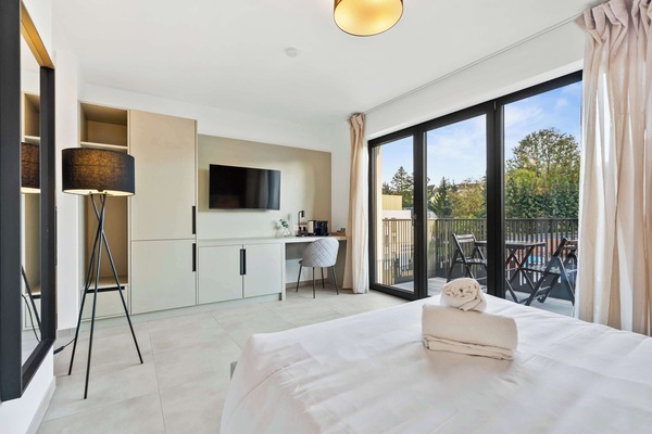 Relaxing Bedroom and Lounge – Enjoy a cozy queen-sized bed paired with a beautifully crafted wooden accent wall.