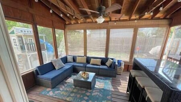 A covered outdoor seating area with a sectional sofa, a small table, and a bar area. - Pool! Arcade! Theatre Room! Firepit! 4 BR (Lincoln)