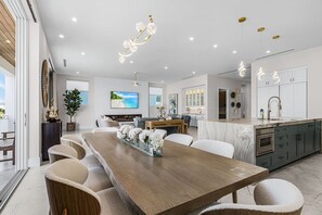 Eine moderne Küche mit Marmorarbeitsplatte, einem Einbauofen und einem Waschbecken mit goldenen Armaturen.