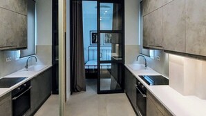 Een moderne keuken met twee spoelbakken, een eethoek met uitzicht en een schuifdeur naar een balkon.