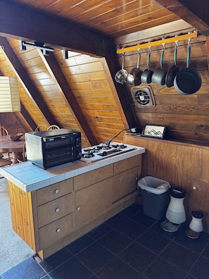 Eine Küche mit Herd, Mikrowelle und Holzschränken.