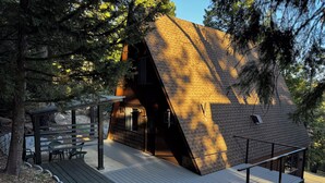 A cabin with a sloped roof, a deck, and a covered outdoor seating area. - Mid-Century 1960s A-Frame Cabin – Mountain Views - 5 mi to Snow Valley (Running Springs)