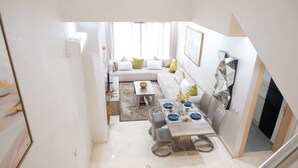 A modern living room with a dining area, a sofa, and a coffee table. - Premium central duplex 120m2 + Garage and high-speed WiFi (Dar-el-Beida)