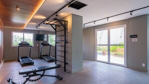 Ein geräumiger Raum mit Klimmzugstange, zwei Laufbändern und einer Trainingsbank.