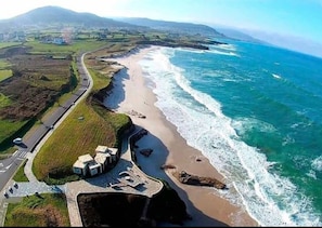 An aerial view of a coastal area with a road, beach, and buildings. - Vanira-Mar Apartment (New) (Foz)