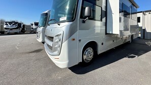 A white RV with a large sliding door, a front grill, and a license plate. - 2025 RV with 2 full baths sleeps 9 (Coram)