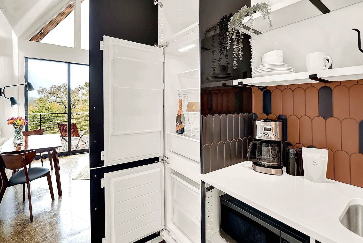 A modern kitchen with a built-in oven, a coffee machine, and a sink.