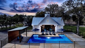 A house with a swimming pool, a covered patio, and a view of the sky. - Wyldwood Modern Cabin - BRAND NEW! (Wimberley)