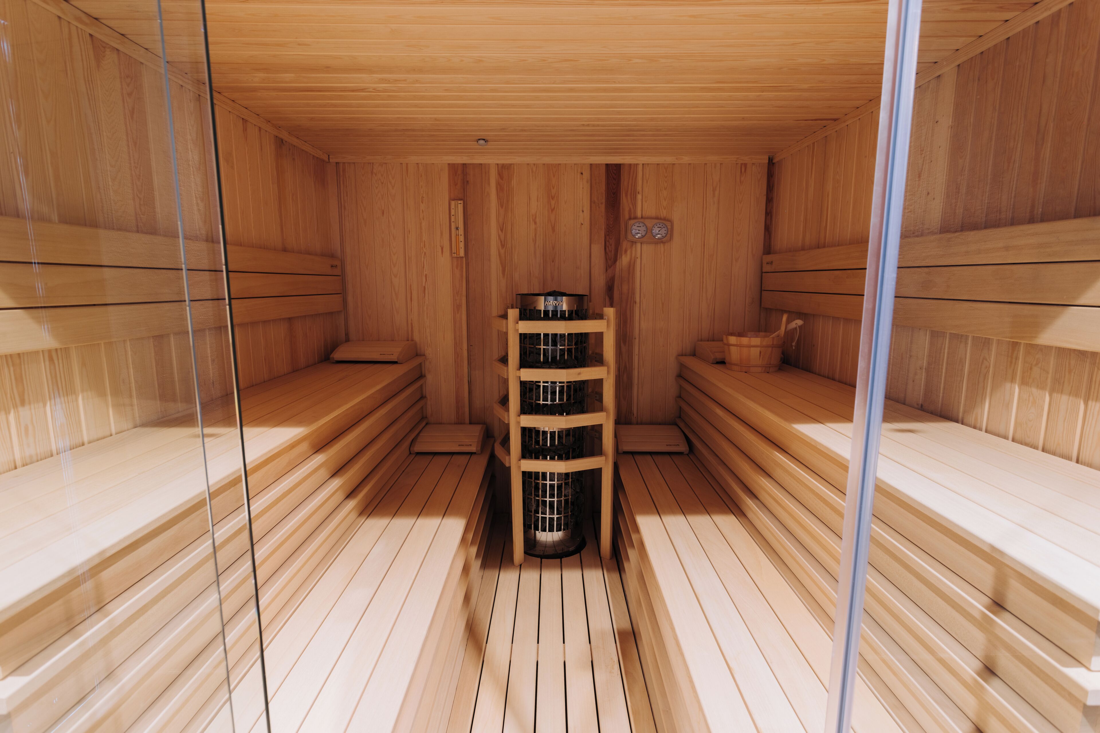 A sauna with wooden benches and a central heater.