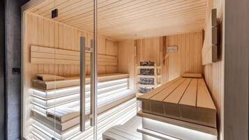 Uma sauna com bancos de madeira e divisória de vidro.