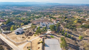 An aerial view of a residential area with houses, a tennis court, and a small building. - Hilltop Estate w/ Tennis Court, Pool, Sauna, Game Room, Theater, Panoramic Views Via de Oro Estate by Avantstay (Temecula)