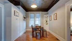 A dining area with a wooden table and chairs, a ceiling light, and framed artwork on the walls. - Park Avenue Retreat (Hot Springs)