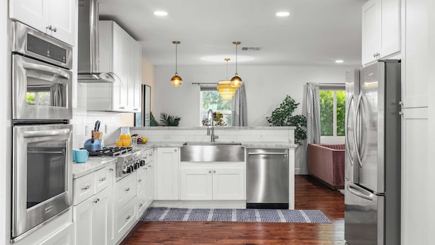 A modern kitchen with stainless steel appliances, white cabinetry, a central island, and a view of the outdoors. - Scottsdale Retreat w/ Private Pool, Outdoor Dining & Close to Old Town Fun Casa Cambridge by Avantstay (Scottsdale)