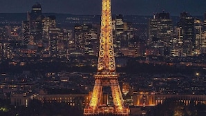 The Eiffel Tower at night with city lights in the background. - Premium Room Paris La Défense Arena (Nanterre)