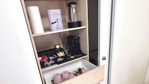 A compact kitchen with a coffee machine, a tea kettle, and a coffee bar setup. - Premium Room Paris La Défense Arena (Nanterre)