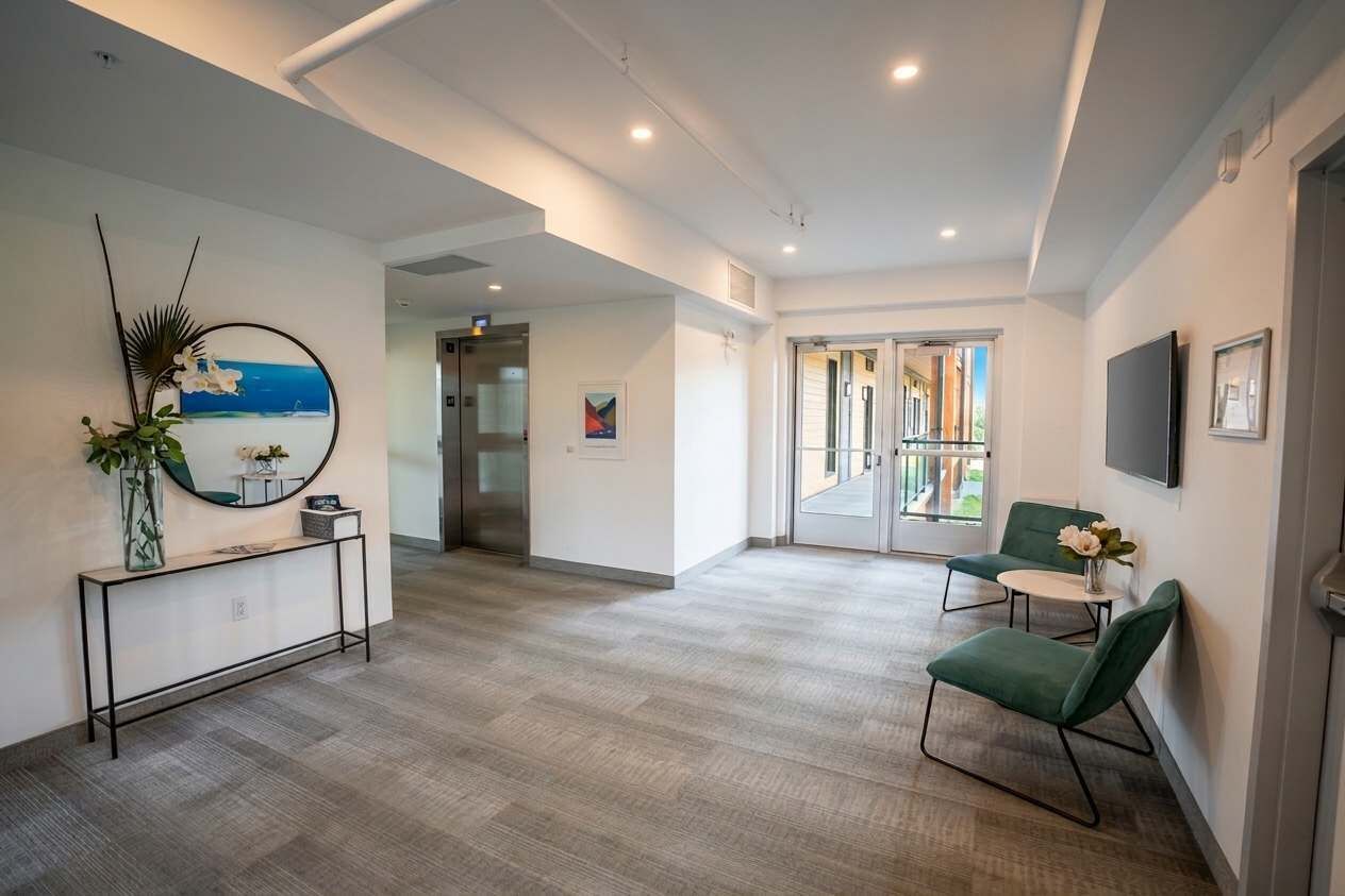 A modern hotel lobby with a console table, seating area, and a large window with a view.