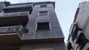 Un immeuble à plusieurs étages doté d’un balcon et d’une enseigne indiquant le nom « OAO EAAANKIYO ».