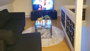 Un soggiorno con televisore, divano, tavolino da caffè e una statuina decorativa a forma di elefante.