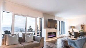 Ein modernes Wohnzimmer mit Sofa, Hocker und Kamin.