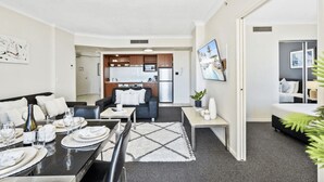 A modern apartment with a dining area, living room, and kitchenette. - Chevron Renaissance - 2 Bed 1 bath Low Floor - 1098 - 2 night - Chevron 2 Bedroom 1 Bathroom Apartment (Surfers Paradise)