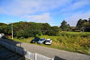Een verhard parkeerterrein met vier geparkeerde auto's.
