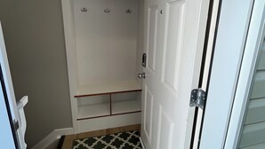 A walk-in closet with a door, a light fixture above, and a patterned rug at the entrance. - Bright & Cozy Basement Suite – Perfect for Work or Adventure (Fort Saskatchewan)