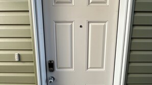 A white door with a rectangular panel design, a doorbell, and a mail slot. - Bright & Cozy Basement Suite – Perfect for Work or Adventure (Fort Saskatchewan)