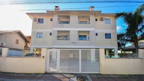 A multi-story building with balconies, a gated entrance, and a sign indicating 'CAMPINHAS'.