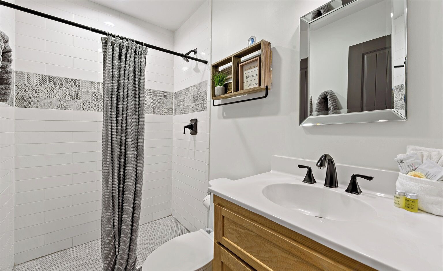 Un baño moderno con ducha, inodoro y lavamanos.