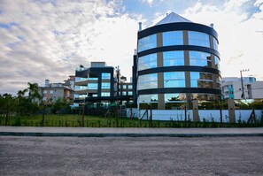 A modern building with a curved facade and multiple windows. - Gaivotas Golden Luxo a 200m praia-NIN012 (Florianópolis)