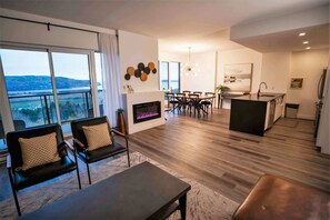 Un salon moderne avec une cheminée, un coin repas et une cuisine.